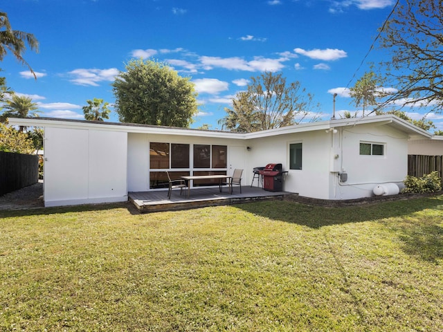 back of house featuring a wooden deck and a yard