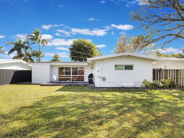 rear view of property with a yard and a patio area