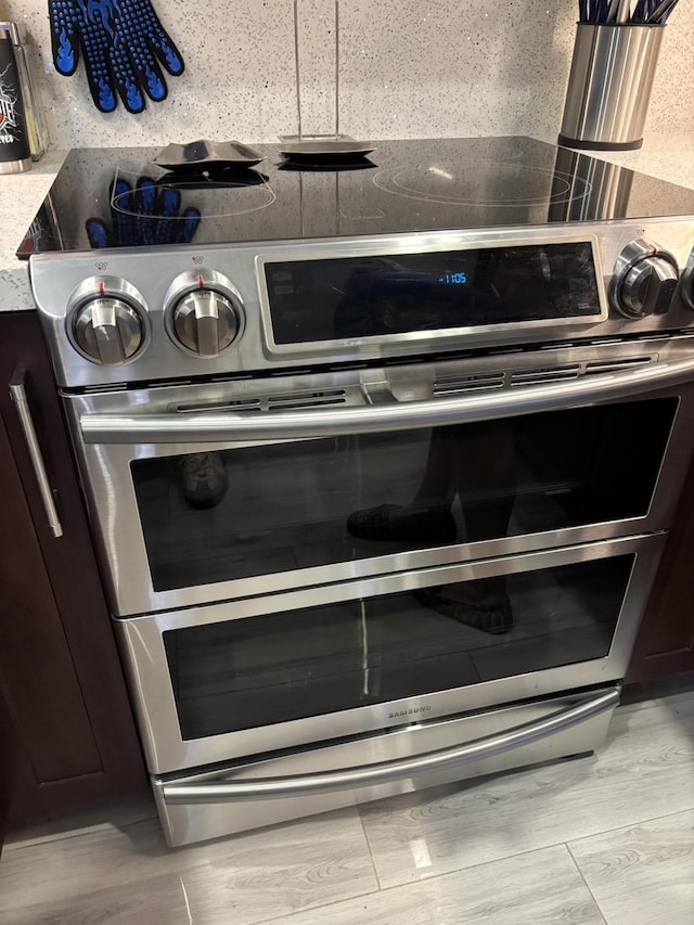 room details with range with two ovens and dark brown cabinetry