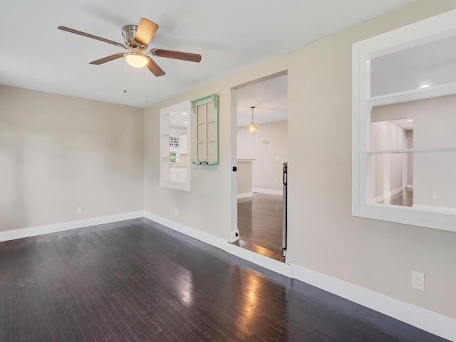 empty room featuring ceiling fan and dark wood-type flooring