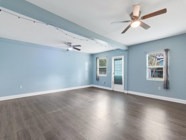 empty room with ceiling fan, dark hardwood / wood-style flooring, and a healthy amount of sunlight