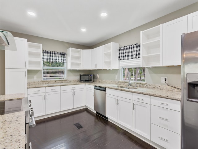 kitchen with appliances with stainless steel finishes, white cabinetry, and light stone counters