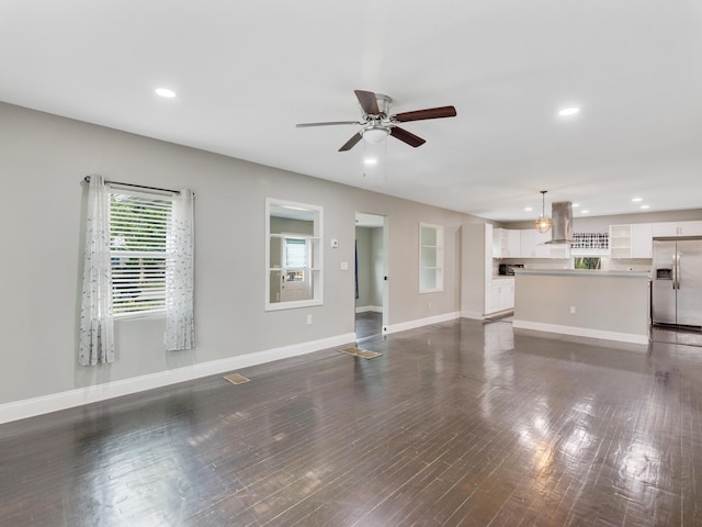 unfurnished living room with ceiling fan and dark hardwood / wood-style floors