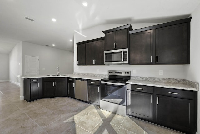 kitchen with sink, vaulted ceiling, light tile patterned floors, kitchen peninsula, and stainless steel appliances