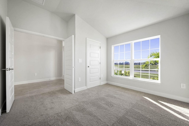 unfurnished bedroom featuring a closet, light colored carpet, and lofted ceiling