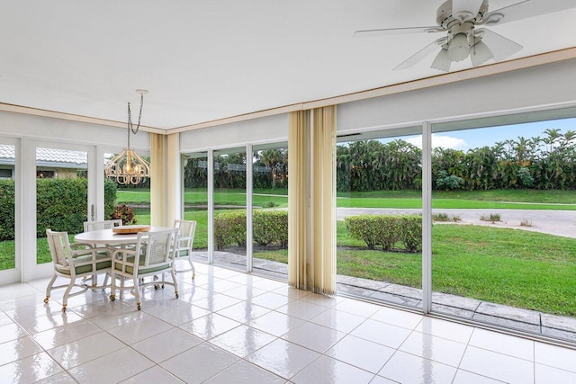 unfurnished sunroom with ceiling fan with notable chandelier