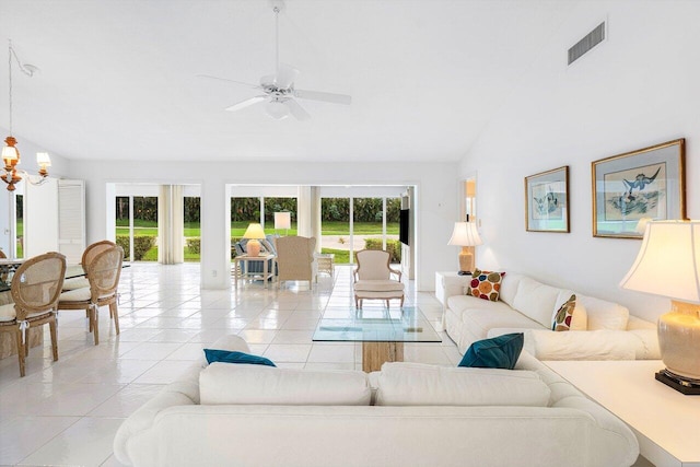 living room featuring ceiling fan with notable chandelier, light tile patterned floors, a wealth of natural light, and lofted ceiling