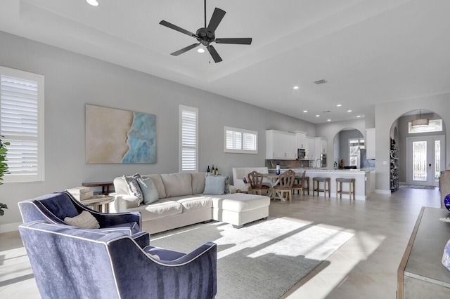 living room featuring ceiling fan and french doors