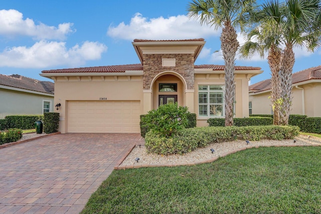 mediterranean / spanish house featuring a garage and a front lawn