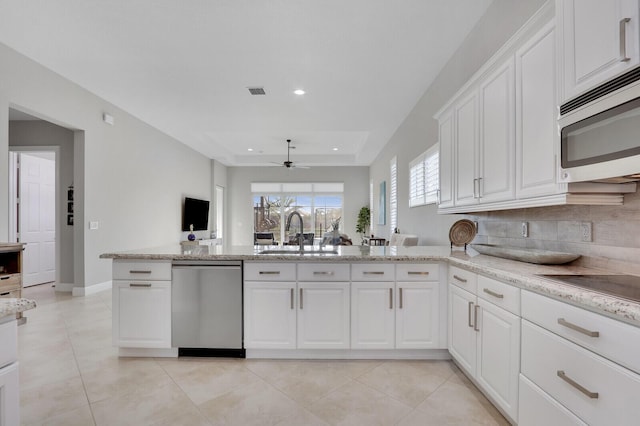 kitchen featuring white cabinets, sink, light stone countertops, light tile patterned floors, and stainless steel appliances