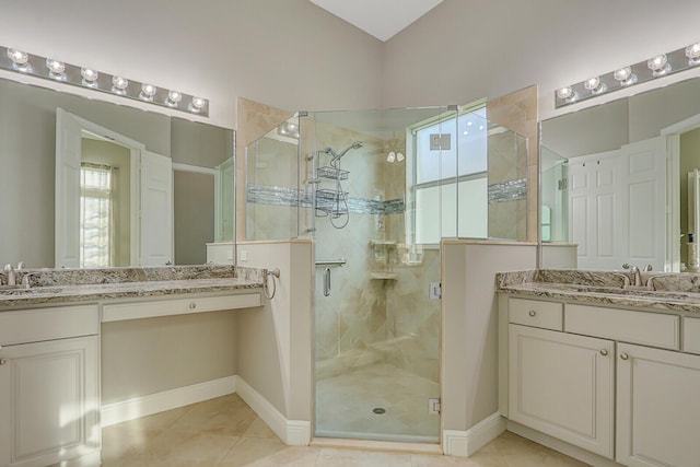 bathroom featuring tile patterned flooring, vanity, and a shower with door