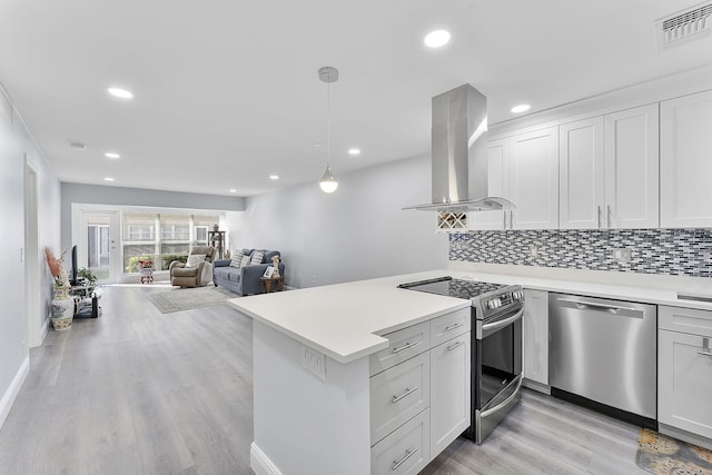 kitchen featuring appliances with stainless steel finishes, white cabinets, island range hood, and decorative light fixtures