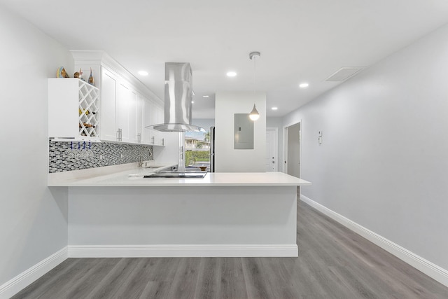 kitchen featuring white cabinets, island exhaust hood, decorative light fixtures, and kitchen peninsula