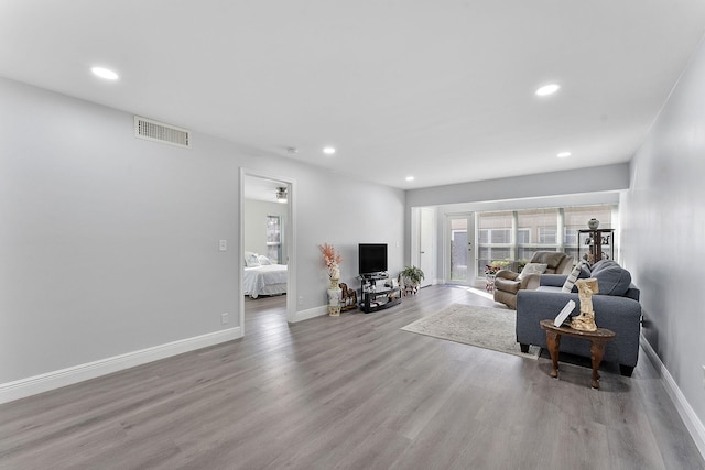 living room with ceiling fan and light hardwood / wood-style flooring