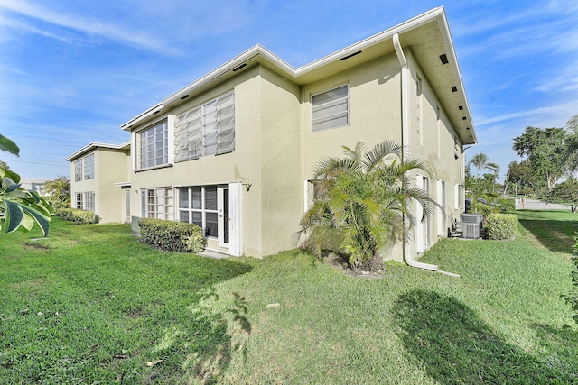 rear view of house with a yard and central AC unit