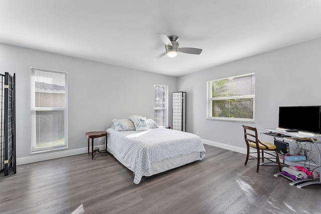 bedroom featuring ceiling fan, wood-type flooring, and multiple windows