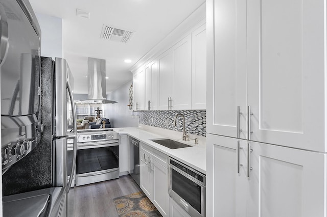 kitchen featuring stainless steel appliances, white cabinetry, sink, and island exhaust hood