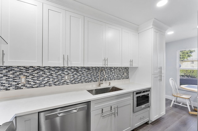 kitchen featuring dishwasher, tasteful backsplash, dark hardwood / wood-style flooring, white cabinets, and sink