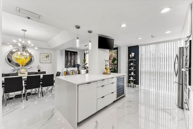 kitchen with decorative light fixtures, white cabinets, an inviting chandelier, and a kitchen island