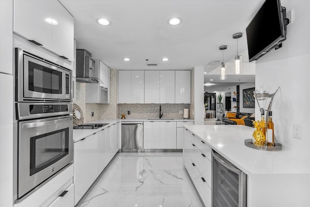 kitchen with decorative light fixtures, sink, stainless steel appliances, white cabinets, and beverage cooler