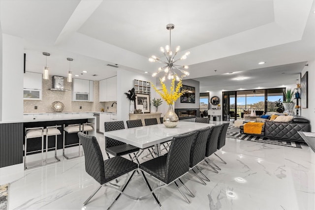 dining room with a chandelier, a tray ceiling, and sink