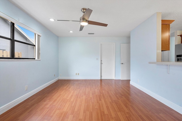 unfurnished room with ceiling fan and light wood-type flooring