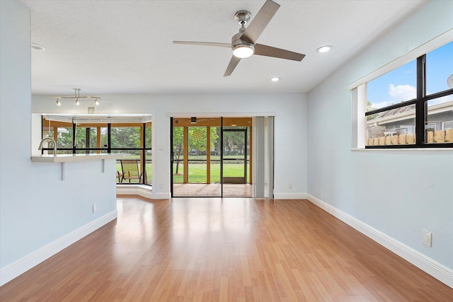 unfurnished living room featuring ceiling fan and light hardwood / wood-style floors