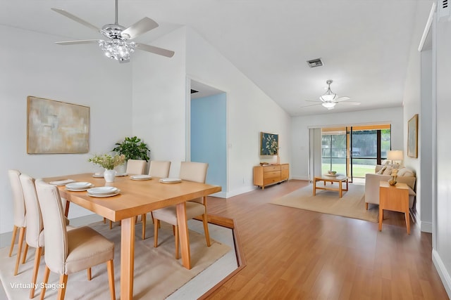 dining space with hardwood / wood-style floors, ceiling fan, and lofted ceiling