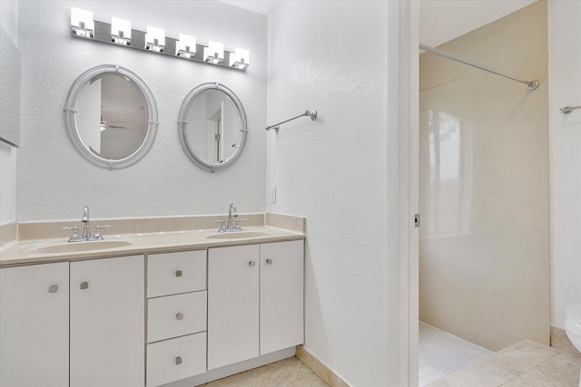 bathroom with toilet, vanity, and tile patterned floors