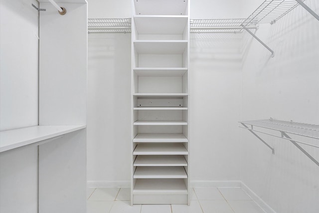 walk in closet with light tile patterned floors