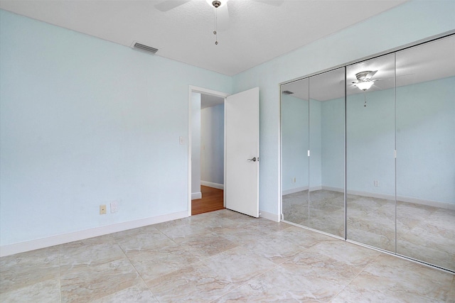 unfurnished bedroom with ceiling fan and a closet