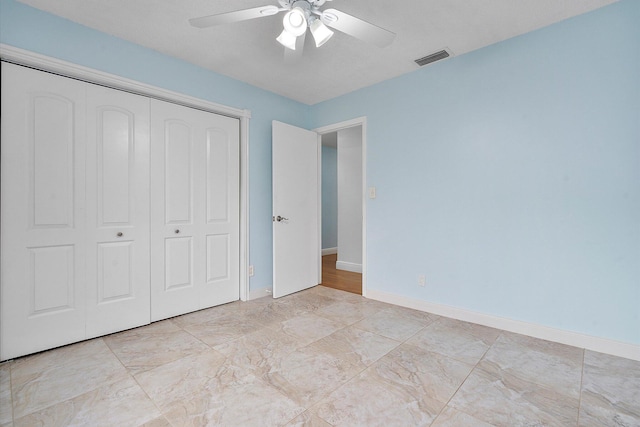 unfurnished bedroom with ceiling fan and a closet