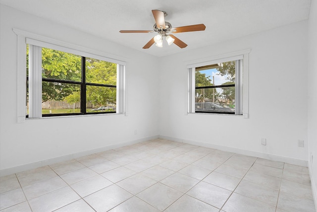 spare room with light tile patterned floors and ceiling fan