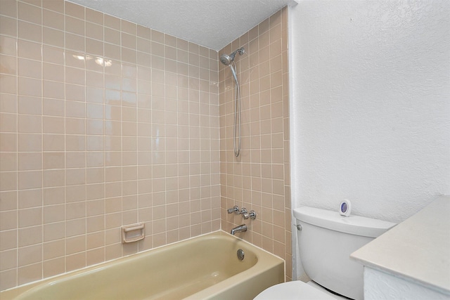 bathroom featuring toilet, a textured ceiling, and tiled shower / bath