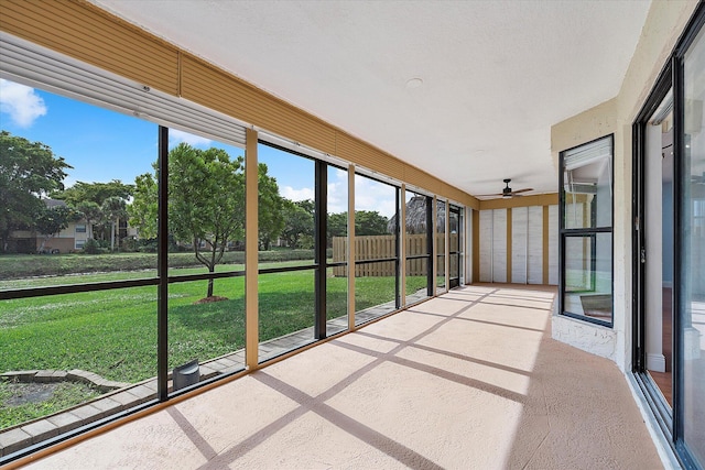 unfurnished sunroom featuring ceiling fan