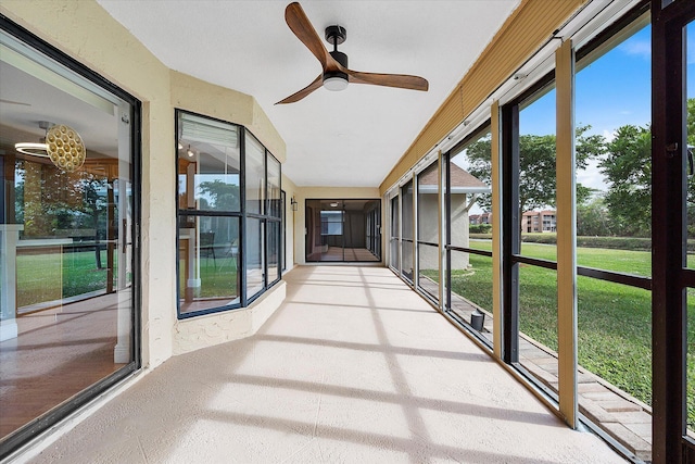 unfurnished sunroom featuring ceiling fan and a healthy amount of sunlight