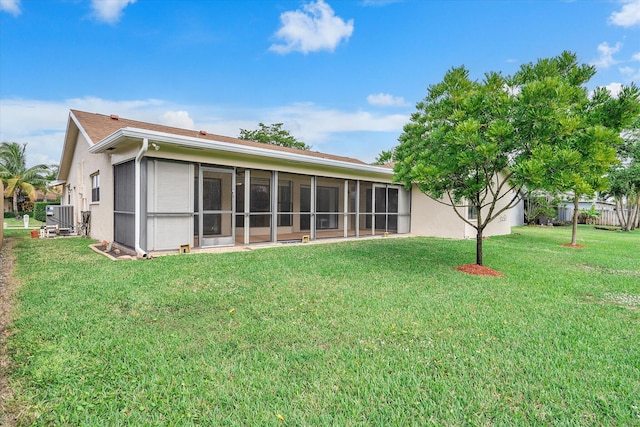 rear view of property with a sunroom and a lawn