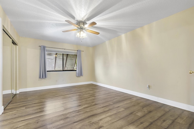 spare room featuring wood-type flooring, a textured ceiling, and ceiling fan