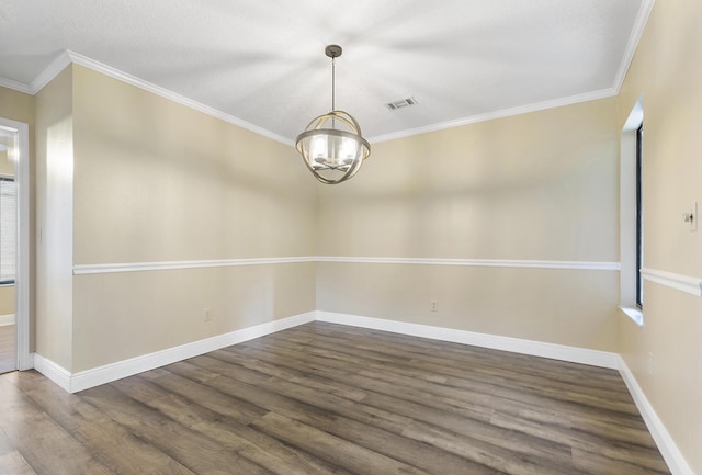 spare room with ornamental molding, dark wood-type flooring, and a notable chandelier