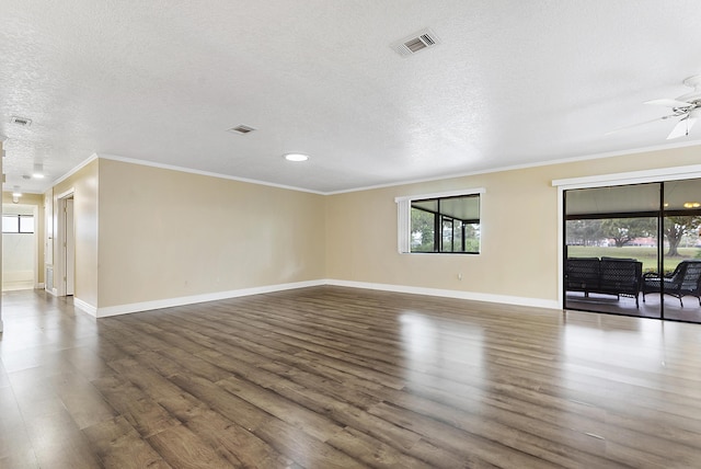 unfurnished living room featuring a textured ceiling, ceiling fan, ornamental molding, and dark wood-type flooring