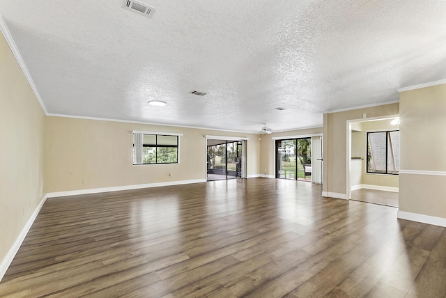 spare room with dark hardwood / wood-style floors, ceiling fan, crown molding, and a wealth of natural light