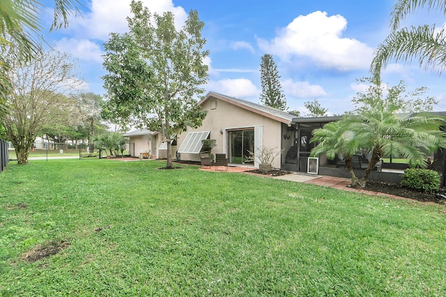 back of house featuring a lawn and a patio area