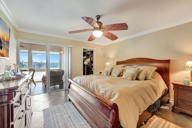 tiled bedroom featuring ceiling fan, access to outside, a walk in closet, a closet, and ornamental molding