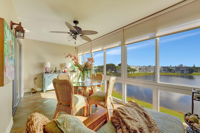 sunroom / solarium featuring a water view and ceiling fan