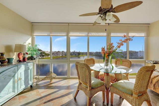 sunroom / solarium with a water view and ceiling fan