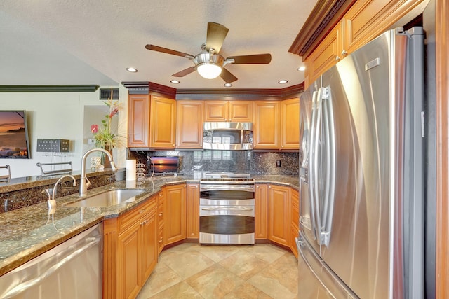 kitchen featuring sink, ceiling fan, decorative backsplash, stone countertops, and stainless steel appliances