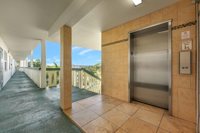 view of patio featuring elevator and a balcony