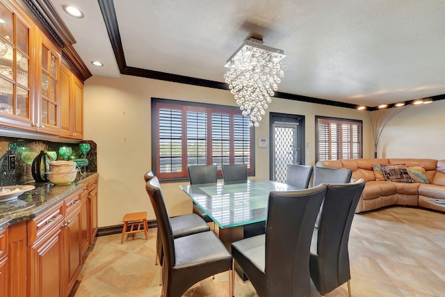 dining space featuring plenty of natural light, a chandelier, and ornamental molding