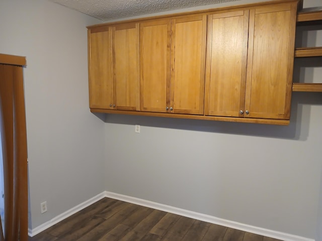 clothes washing area featuring a textured ceiling and dark hardwood / wood-style floors