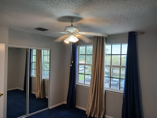 unfurnished bedroom featuring multiple windows, a closet, and ceiling fan